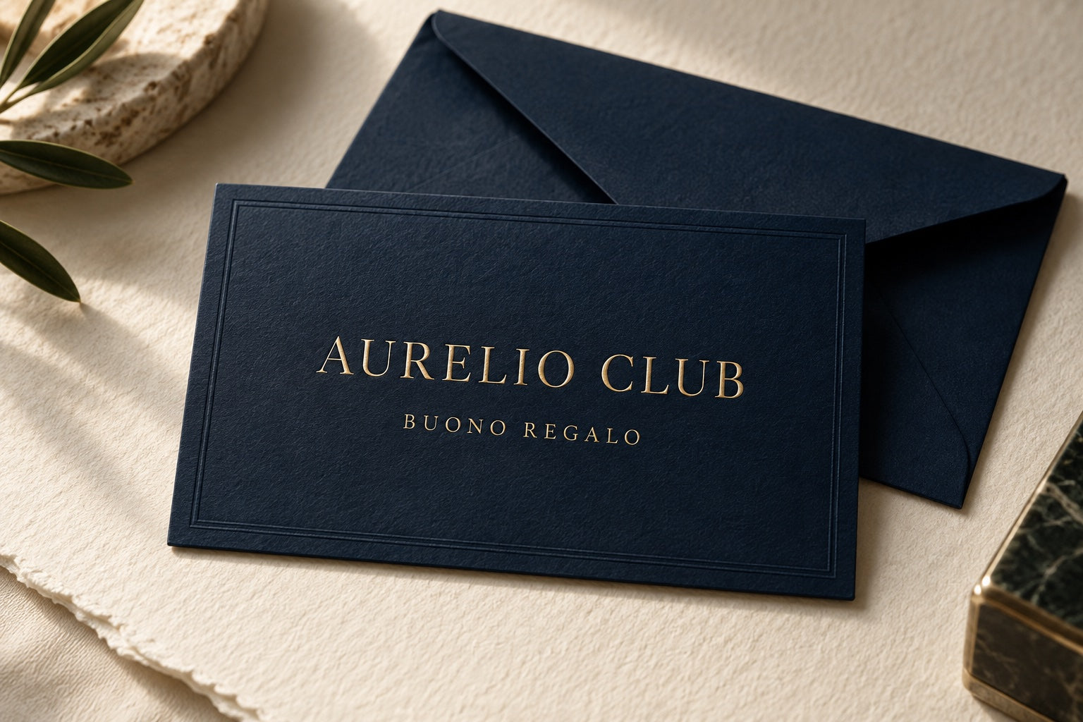 Buono regalo digitale Aurelio Club: carta blu navy con scritte dorate e busta su fondo avorio